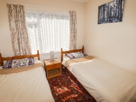 A bedroom with two beds and a bedside table at Cottage 1 in Tenby