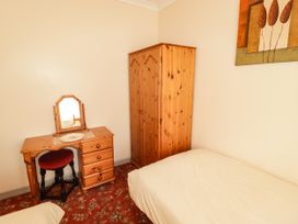 A bedroom with a bed and dressing table at Cottage 1 in Tenby