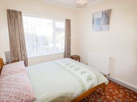 A bedroom with a bed and a window at Cottage 1 in Tenby