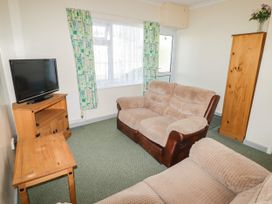A living room with a television and seating at Cottage 3 in Tenby