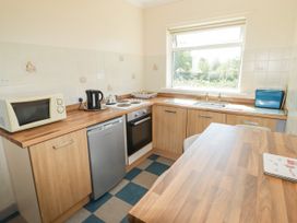 A kitchen with appliances and countertop at Cottage 3 in Tenby