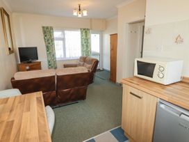 A living room with a sofa, television and microwave at Cottage 3 in Tenby