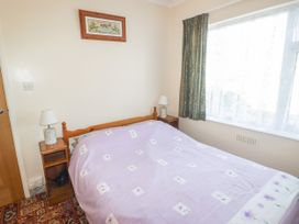 A bedroom with a bed and bedside lamps at Cottage 3 in Tenby