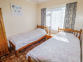 A bedroom with two beds and a nightstand at Cottage 3 in Tenby