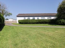 An outdoor view of a house surrounded by grass and hedges at Cottage 3 in Tenby