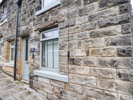An exterior view of a stone house with a door and windows at The Snug Glaisdale