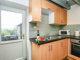 A kitchen with wooden cabinets and a sink at The Snug Glaisdale