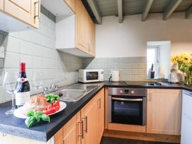 A kitchen with sink oven and microwave at The Snug Glaisdale