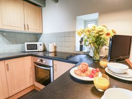 A kitchen with microwave and flowers on the counter at The Snug Glaisdale