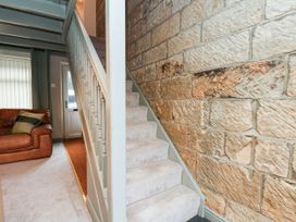 A hallway with a staircase and sofa at The Snug Glaisdale