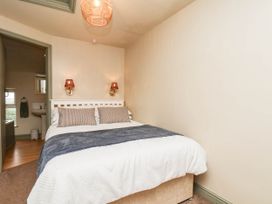 A bedroom with a bed and a mirror at The Snug Glaisdale