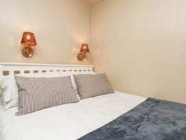 A bedroom with a bed and wall lamps at The Snug Glaisdale