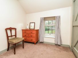 A bedroom with a chair and dresser at The Snug Glaisdale