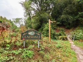 A welcome sign for Glaisdale with a pathway and bridge at Glaisdale