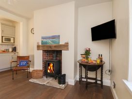 A living room with a fireplace and a table at 4 Studley Terrace Whitby
