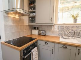 A kitchen with a stove, oven, sink, and toaster at 4 Studley Terrace in Whitby
