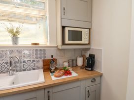 A kitchen with a sink and microwave at 4 Studley Terrace in Whitby