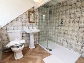 A bathroom with a shower, sink, and toilet at 4 Studley Terrace Whitby