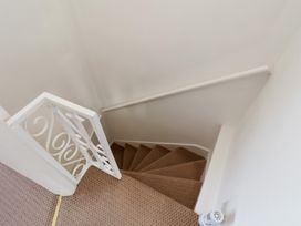 A staircase with a handrail and carpet at 4 Studley Terrace in Whitby