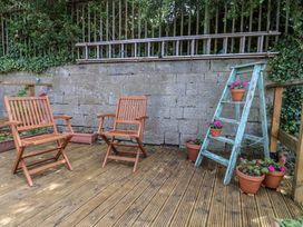 A garden with wooden chairs and potted plants at 4 Studley Terrace in Whitby