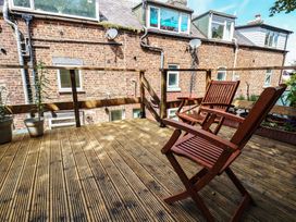 An outdoor terrace with wooden decking and chairs at 4 Studley Terrace Whitby