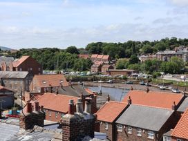 A view of houses and boats by the water at 4 Studley Terrace in Whitby