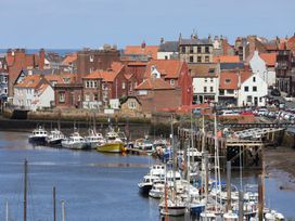 A view of boats and buildings in a harbor at 4 Studley Terrace in Whitby