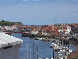A harbor with boats and buildings at 4 Studley Terrace in Whitby
