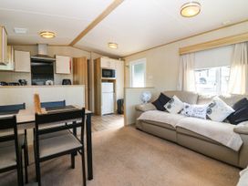 A living room with a kitchen area and dining table at Rowan View 251