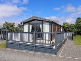 A cabin with a deck and railings at Lodge - Plot 18 Malton