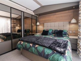 A bedroom with a bed and mirrors at Lodge - Plot 18 Near Sherburn