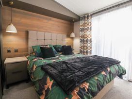 A bedroom with a bed and nightstand at Lodge - Plot 18 near Sherburn