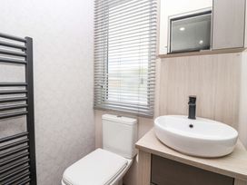 A bathroom with a toilet and sink at Lodge - Plot 18 Near Sherburn
