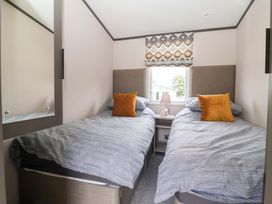 A bedroom with two beds and a lamp on a nightstand at Lodge - Plot 18 Near Sherburn
