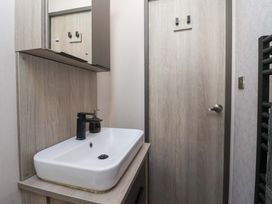 A bathroom with a sink and mirror at Lodge - Plot 18 Near Sherburn