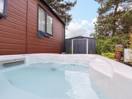 A hot tub with a shed and surrounding plants at Lodge - Plot 18 Near Sherburn