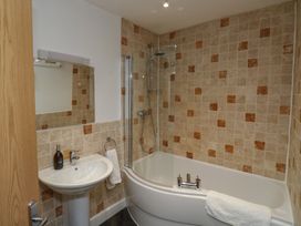 A bathroom with a bath, sink, and shower at 15D Foss Street Dartmouth