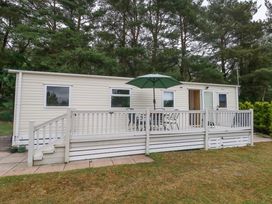 A mobile home with a deck and table at Foxglove 4 Ringwood