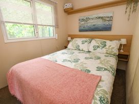 A bedroom with a bed and two bedside lamps at Foxglove 4 in Ringwood