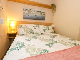 A bedroom with a bed and bedside lamp at Foxglove 4 in Ringwood