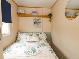 A bedroom with a bed and decorative items at Foxglove 4 in Ringwood