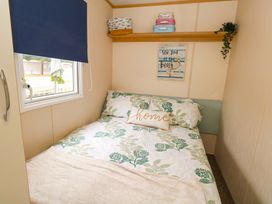 A bedroom with a bed and shelf at Foxglove 4 in Ringwood