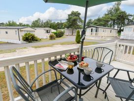 An outdoor patio area with a table and chairs at Foxglove 4 in Ringwood