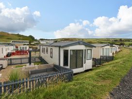 A mobile home with a fenced garden area at Caravan A7 in Bridport