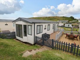 A caravan with a deck and fence at Caravan A7 in Bridport