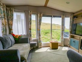 A living room with a sofa and television at Caravan A7 in Bridport