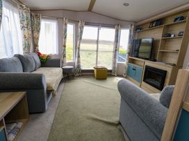 A living room with a sofa and television at Caravan A7 in Bridport