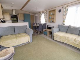 A living room with sofas and dining table at Caravan A7 in Bridport