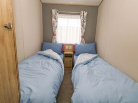 A bedroom with two single beds and a window at Caravan A7 in Bridport