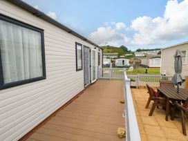 An outdoor deck with a table and chairs at Caravan A7 in Bridport
